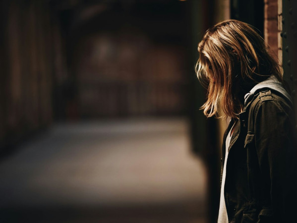Image shows girl with depression, bowing her in head against a ball - image credit Eric Ward, Unsplash