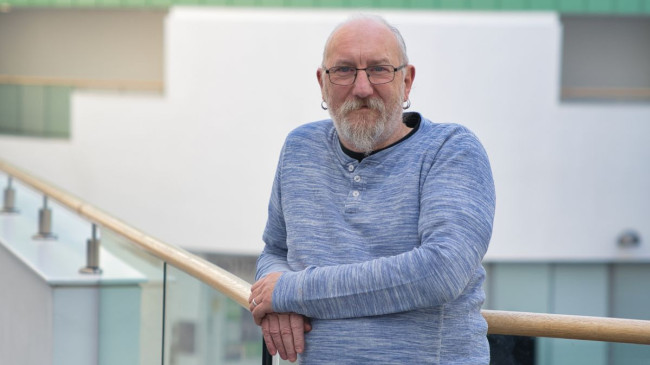 Phil Chaplain leaning on a balustrade in the Sir Ian Wood Building