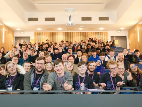 Staff and students posing in a lecture theatre Staff and students posing in a lecture theatre