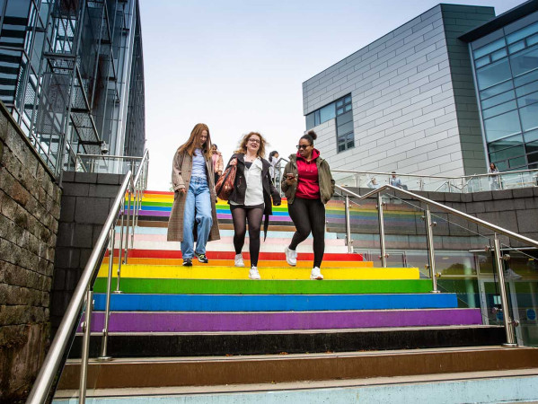 students walk down rainbow stairs at RGU campus
