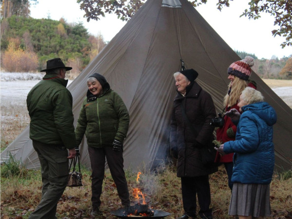 A group of elders standing next to a tent A group of elders standing next to a tent