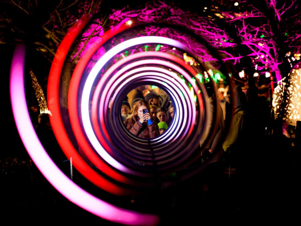 Image shows Spectra 2023 opening festival, women with phone looking through light display - Credit Ian Georgeson