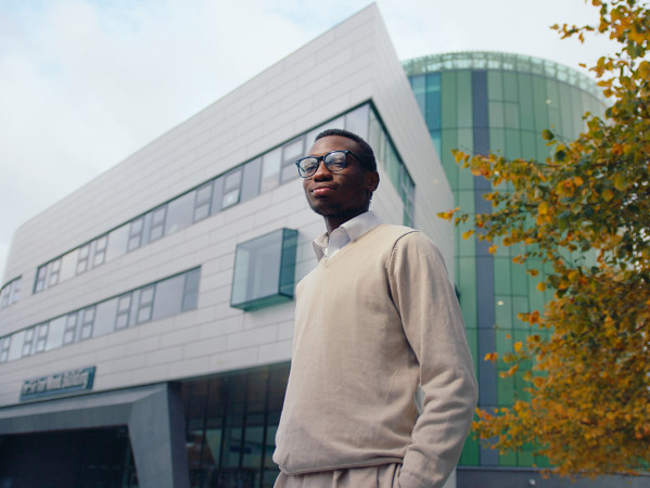 man stood in front of sir ian wood building on campus