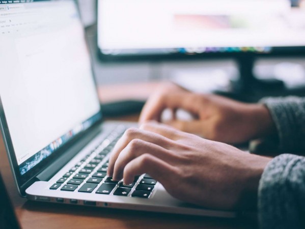 man typing on a laptop