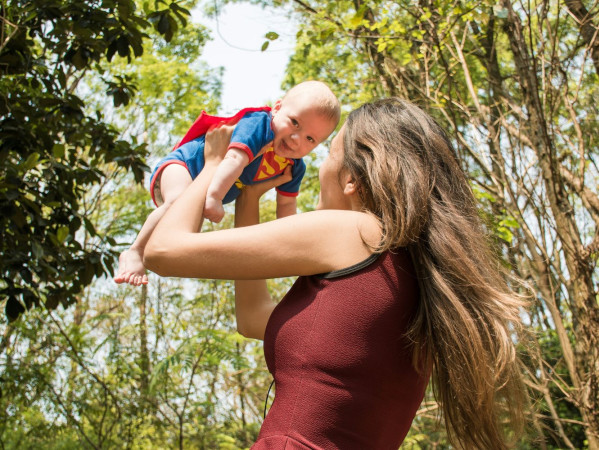 Image shows mother lifting a baby in the air, wearing a superman baby grow - Credit: Valeria Zoncoll on Unsplash Image shows mother lifting a baby in the air, wearing a superman baby grow - Credit: Valeria Zoncoll on Unsplash
