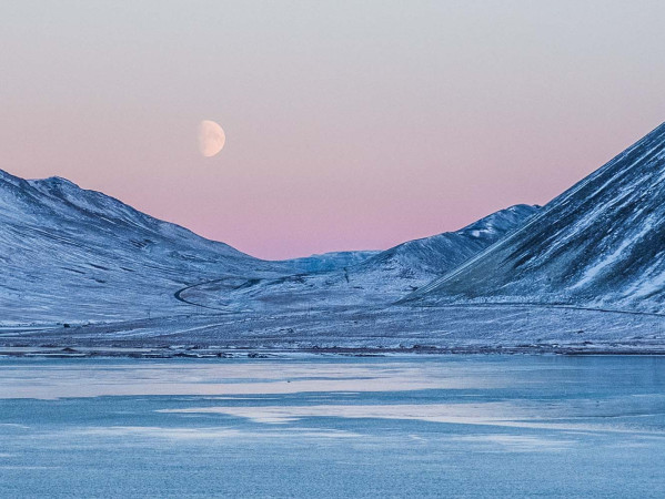 mountains in the Arctic with moon in sky