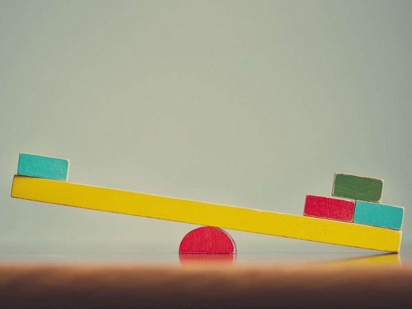 unequal coloured wooden blocks on a balance