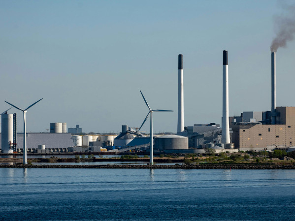 wind turbines next to a factory