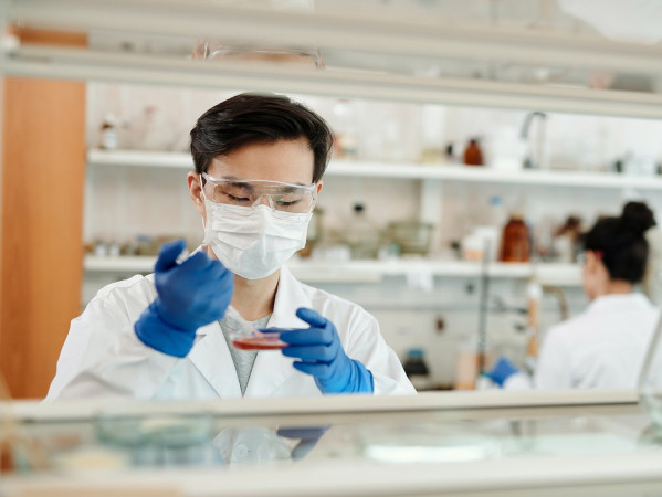 person wearing a mask in a lab using equiptment