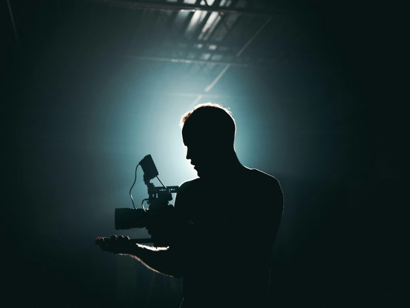 sillhouette of a man standing near a microphone