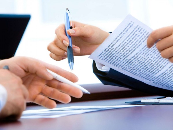 hands with a laptop and paperwork