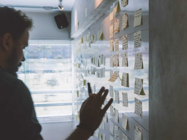 Person pointing at a whiteboard with a pen