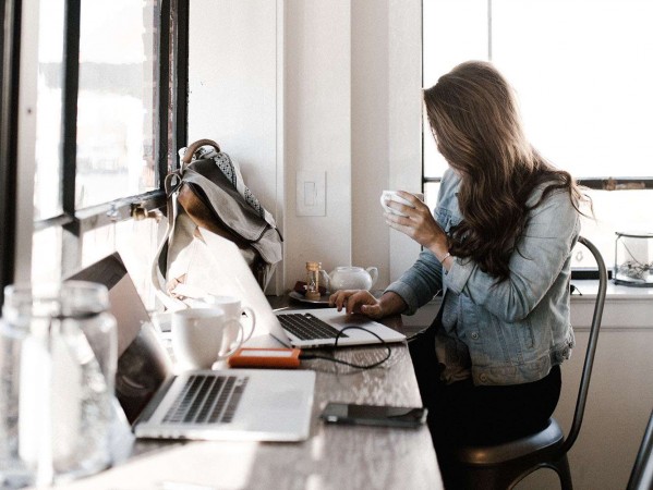 woman with a coffee on a laptop