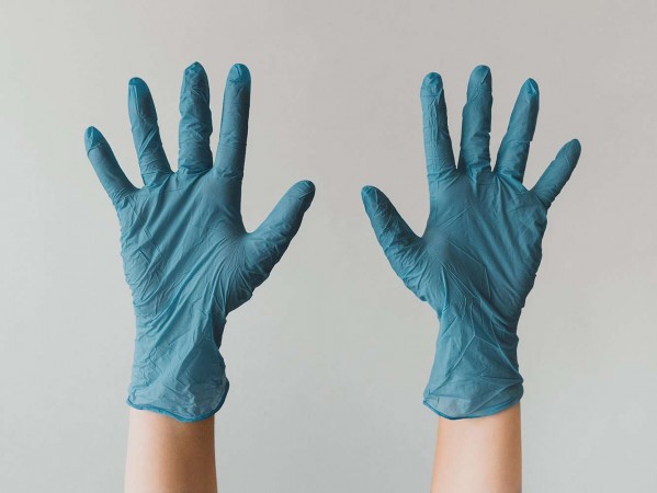 blue medical gloves on outstretched hands