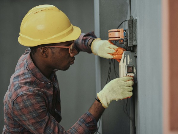 man with hard hat working on electrics man with hard hat working on electrics