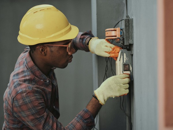 man with hard hat working on electrics