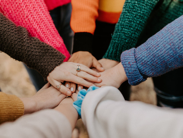 people putting their hands together in the middle