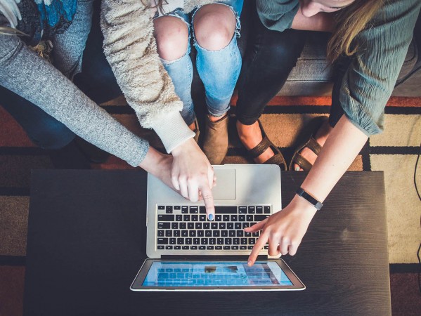 people pointing at a laptop