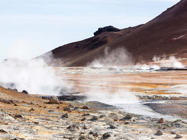 a hillside landscape with air vents causing gas clouds