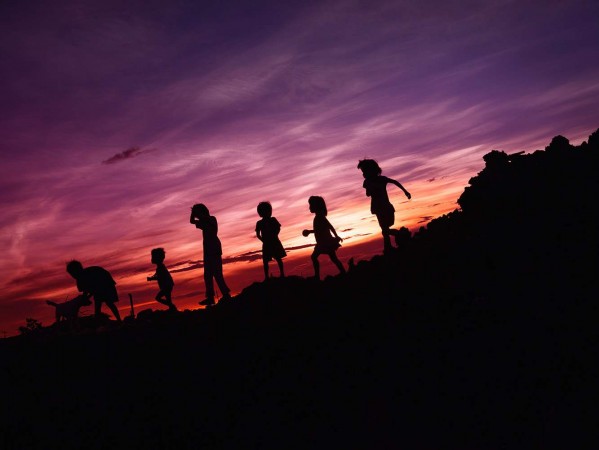 children silhouetted in the sunset
